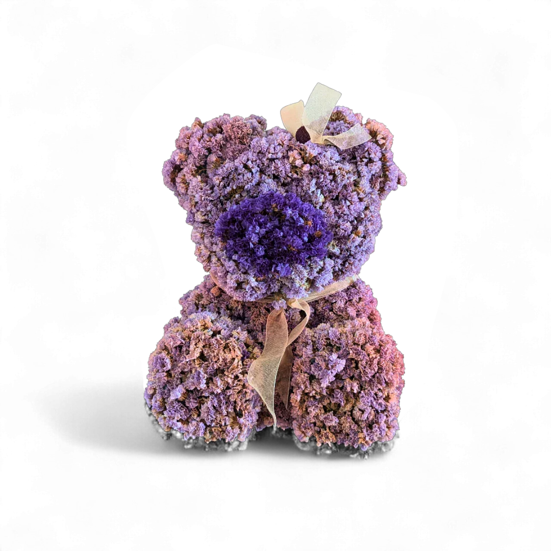 דובי פרחים סגולים ורודים עשוי פרחים מלאכותיים עם סרט לבן על רקע שקוף